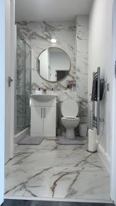 a bathroom with a sink and a toilet and a mirror at Luxury apartment in dudley in West Bromwich