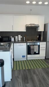 een keuken met witte apparatuur en een groen tapijt bij Luxury apartment in dudley in West Bromwich