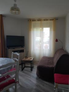 1 dormitorio con 1 cama, TV y mesa en Maison de bourg, comme a la maison ! en Cheviré-le-Rouge