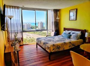 a bedroom with a bed and a large window at Soothing Hawaii Condo - 18F in Honolulu
