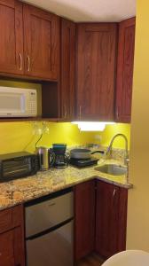 a kitchen with a sink and a microwave at Soothing Hawaii Condo - 18F in Honolulu