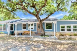 una casa azul con un árbol delante en Downtown Studio 2 at Beer Ranch Project Inn, en Wimberley