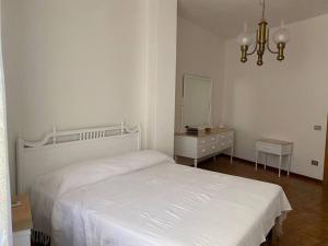 a white bedroom with a bed and a mirror at "Domus Cannas"-Casa Indipendente- in Cagliari