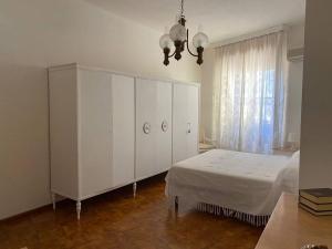 a bedroom with a white bed and a large cabinet at "Domus Cannas"-Casa Indipendente- in Cagliari