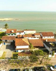 a group of buildings with the ocean in the background at Pousada das Tartarugas in Rio das Ostras