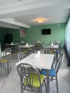 a dining room with white tables and chairs at Planet kazbegi in Stepantsminda