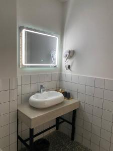 een badkamer met een wastafel met een spiegel en een raam bij H2O in Ureki