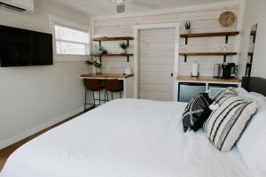 1 Schlafzimmer mit einem weißen Bett und einer Küche in der Unterkunft Downtown Studio 3 at Beer Ranch Project Inn in Wimberley