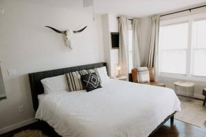 ein Schlafzimmer mit einem Bett mit einer Antilope an der Wand in der Unterkunft Downtown Studio 3 at Beer Ranch Project Inn in Wimberley