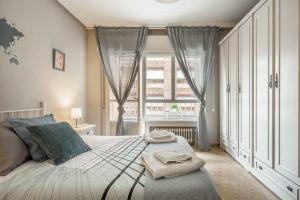 a bedroom with a large bed with two towels on it at Apto Lourmar El Berrón in Berrón