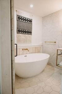 ein Bad mit einer großen weißen Badewanne in einem Zimmer in der Unterkunft Downtown Studio 3 at Beer Ranch Project Inn in Wimberley