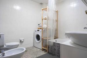 a bathroom with a washing machine and a sink at Apto Lourmar El Berrón in Berrón +17 photos