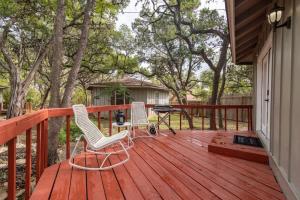two chairs and a grill on a wooden deck at Downtown Lonestar Bungalow at Beer Ranch Project in Wimberley