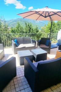 patio con sedie, tavoli e ombrellone di Casa Picone - Gerês a Ventosa