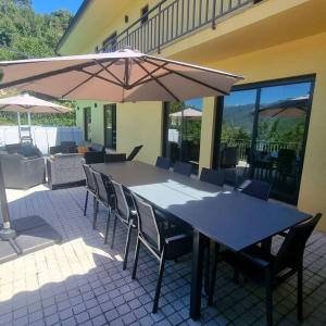 a table with chairs and an umbrella on a patio at Casa Picone - Gerês in Ventosa