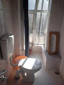 een badkamer met een toilet en een raam bij Summer and winter homestay Turtuk Youl in Turtok
