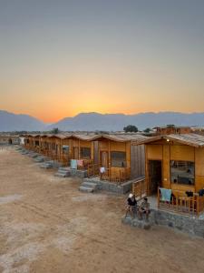 una fila de casas en el desierto al atardecer en Star Dune Camp en Nuweiba