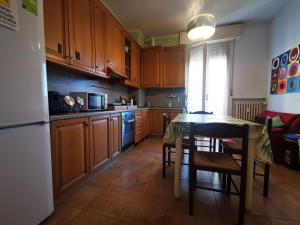 a kitchen with wooden cabinets and a table with chairs at B&B Ospedale Maggiore Parma affittacamere in Parma