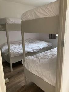 Katil dua tingkat atau katil-katil dua tingkat dalam bilik di Luxe chalet met airco bij bos en zwemwater