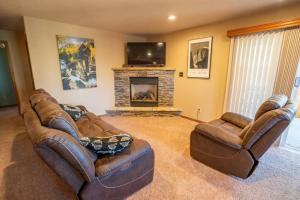 a living room with two leather couches and a fireplace at Bear Creek Lodge - Spa - Fire Table - 3min to Trails in Colorado Springs