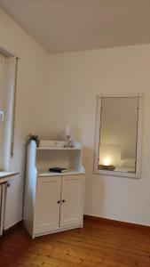 Dieses weiße Zimmer verfügt über einen Spiegel und ein Waschbecken. in der Unterkunft FeWo im Naturschutzgebiet in Hiddenhausen