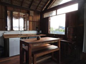 a kitchen with wooden walls and a table and windows at Divino Tatajuba eco-bungalow, beach kite front, amazing view! in Tatajuba +39 photos