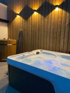 eine Whirlpool-Badewanne mit Licht an einer Holzwand in der Unterkunft Vakantiehuis Joanitas in Bredene + 37 Fotos