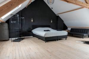 ein Schlafzimmer mit einem Bett und einer schwarzen Wand in der Unterkunft Vakantiehuis Joanitas in Bredene
