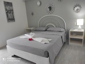 a white bedroom with two beds with towels on them at Villa Preciosa in Bayahibe