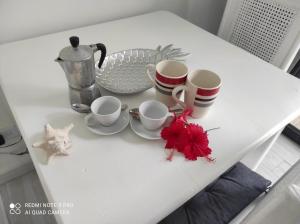 un tavolo bianco con tazze e piattini sopra di Villa Preciosa a Bayahibe