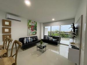 sala de estar con sofá negro y mesa en Apartamento Cartagena Morros Epic 23, en Cartagena de Indias