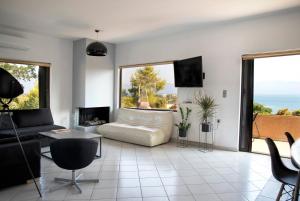 ein Wohnzimmer mit einem Sofa und großen Fenstern in der Unterkunft Seaview Resort in Chalkida