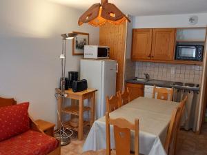 een keuken met een tafel en een witte koelkast bij Appartement Lanslevillard, 2 pièces, 6 personnes - FR-1-508-107 in Lanslevillard