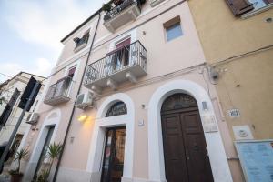 ein Gebäude mit einer braunen Tür und einem Balkon in der Unterkunft Numero 85 in Termoli