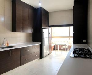 y cocina con nevera y fogones. horno superior en Two bedroom furnished apartment in Amman near Boulevard Abdali. en Amán