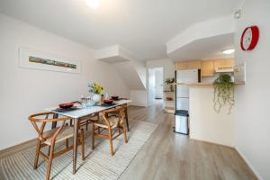 uma cozinha e sala de estar com mesa e cadeiras em Poppy on the Lane - WiFi CBD em Thebarton