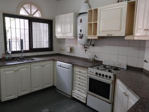 a kitchen with white cabinets and a stove top oven at Why Not Guemes in Cordoba