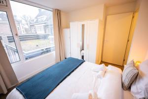 um quarto com uma cama e uma grande janela em Magnificent Two Bedroom Apartment em Eindhoven