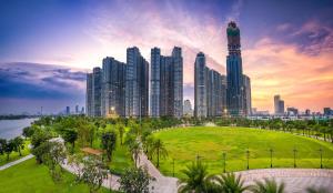 a city skyline with tall buildings and a park at DongDong Luxury Apartment in Vinhomes Central Park in Ho Chi Minh City