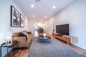 a living room with a couch and a flat screen tv at Black Oak at Brompton – Contemporary Parkside Stay in Bowden