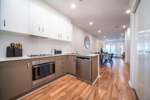 a kitchen with white cabinets and a wooden floor at Black Oak at Brompton in Bowden