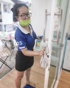 a woman wearing a face mask standing next to a door at Micro Hostel in Bangkok