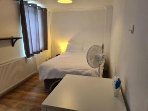 a small room with a bed with a fan at Close To Tower Bridge Central London - 4 Bedroom House - 3 Bathrooms - Free Parking 3 Cars - Sleep 9 in London