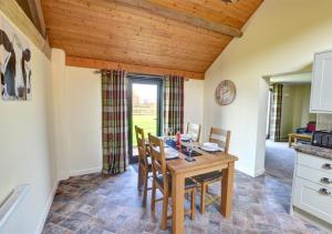 a kitchen and dining room with a wooden table and chairs at Y Beudy in Llandinam