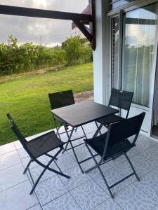 - deux chaises et une table sur une terrasse couverte dans l'établissement Au Gré des Alizés - Kaz Soley Péyi, à Capesterre