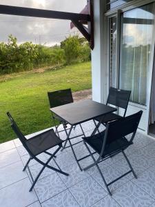 two chairs and a table on a porch at Au Gré des Alizés - Kaz Soley Péyi in Capesterre-de-Marie-Galante