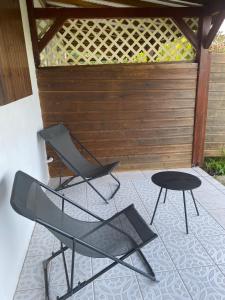 - une terrasse avec 2 chaises et une table dans l'établissement Au Gré des Alizés - Kaz Soley Péyi, à Capesterre