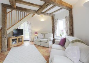 a living room with a white couch and a tv at Sampson's Mill in Wickham Market