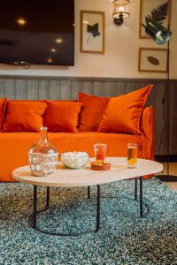 sala de estar con sofá naranja y mesa de centro en Campanile Metz - Jouy-Aux-Arches, en Jouy-aux-Arches
