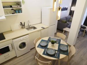 une cuisine et une salle à manger avec une table et un lave-linge dans l'établissement Precioso apartamento en Cuatro Caminos by beBalmy, à Madrid